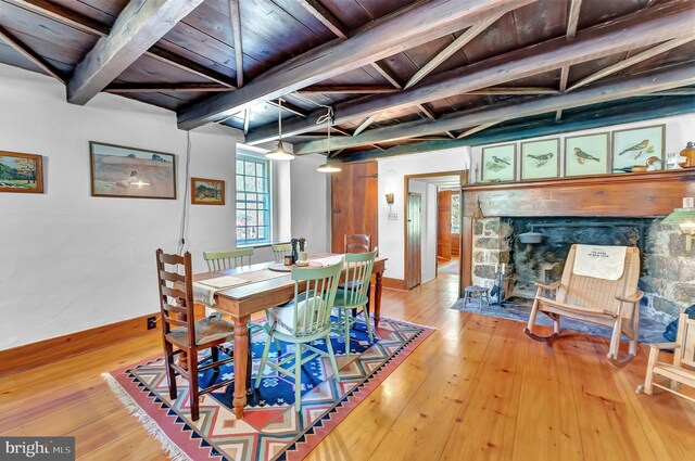 dining area featuring beam ceiling, baseboards, wooden ceiling, light wood-style floors, and coffered ceiling