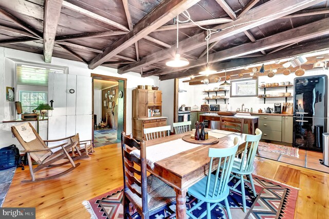 dining room featuring wooden ceiling, beam ceiling, and light wood finished floors
