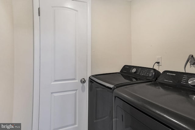washroom with independent washer and dryer and laundry area