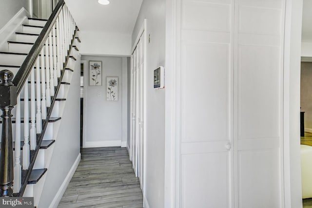 hall featuring recessed lighting, baseboards, wood finished floors, and stairway
