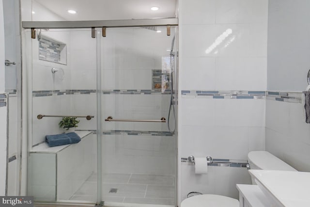 full bath with recessed lighting, tile walls, a shower stall, and toilet