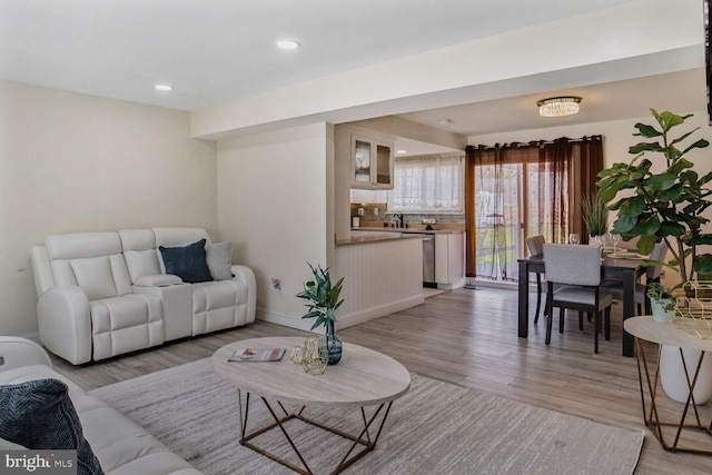 living area featuring recessed lighting, baseboards, and light wood-style floors