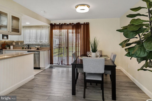 dining space featuring baseboards and light wood-style flooring