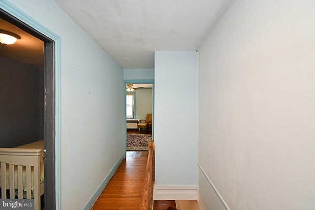 hall featuring baseboards and wood finished floors