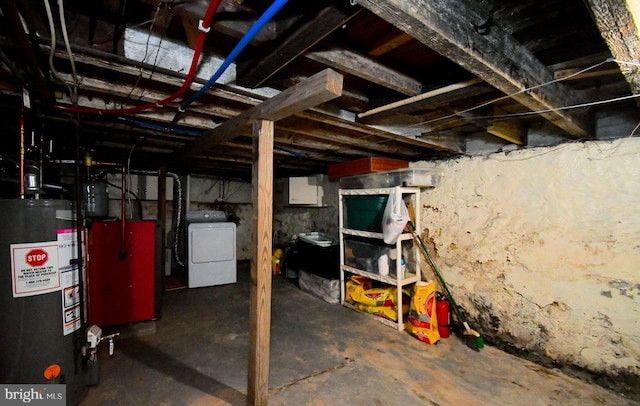 unfinished below grade area featuring water heater, washer / clothes dryer, and a heating unit