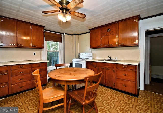 kitchen with a ceiling fan, electric range, light floors, light countertops, and a sink