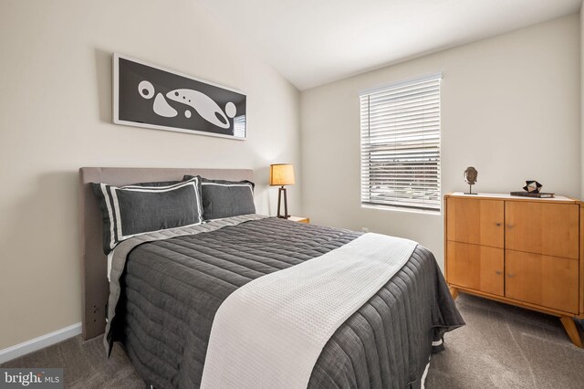 carpeted bedroom featuring baseboards and vaulted ceiling
