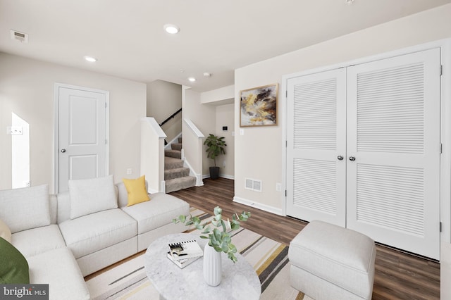 living area featuring recessed lighting, visible vents, wood finished floors, and stairway
