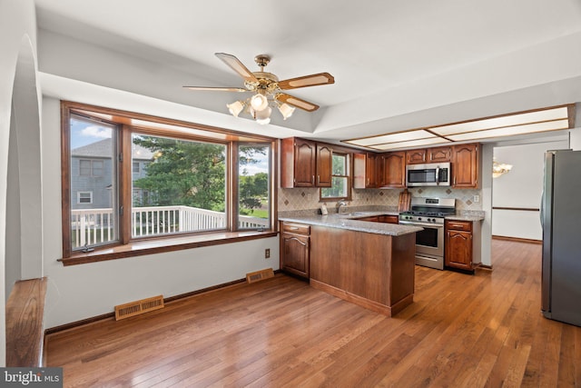 4 Sunflower Ct, Newtown, PA 18940 - kitchen featuring stainless steel appliances, a peninsula, backsplash, hardwood / wood-style flooring, and a sink