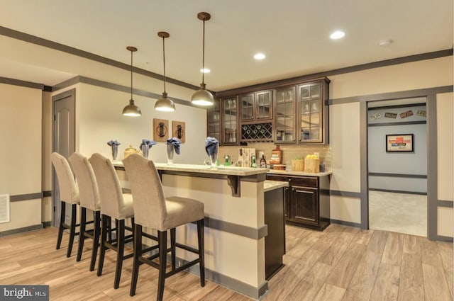 17905 Queen Anne Rd, Upper Marlboro, MD 20774 - bar with light wood-style floors, tasteful backsplash, ornamental molding, and wet bar
