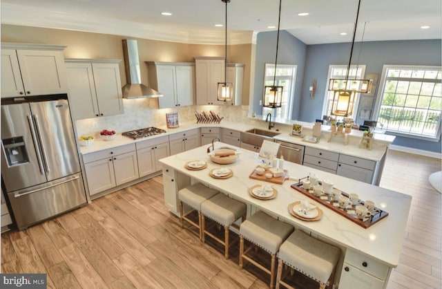 17905 Queen Anne Rd, Upper Marlboro, MD 20774 - kitchen with appliances with stainless steel finishes, a sink, light wood-style floors, wall chimney exhaust hood, and a peninsula