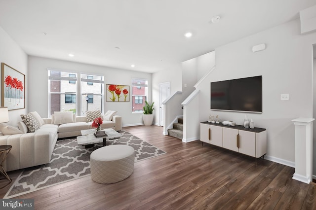 living room featuring recessed lighting, baseboards, dark wood-style flooring, and stairs