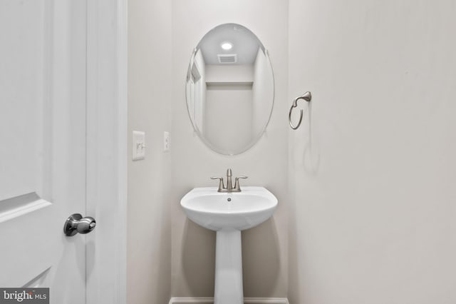 bathroom with visible vents, a sink, and baseboards