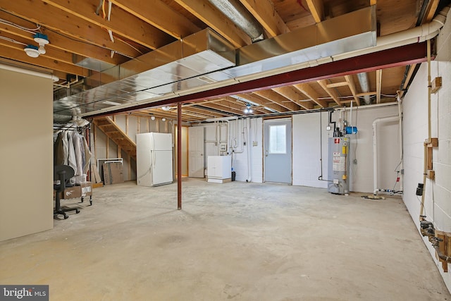 below grade area with water heater, freestanding refrigerator, and washer / clothes dryer