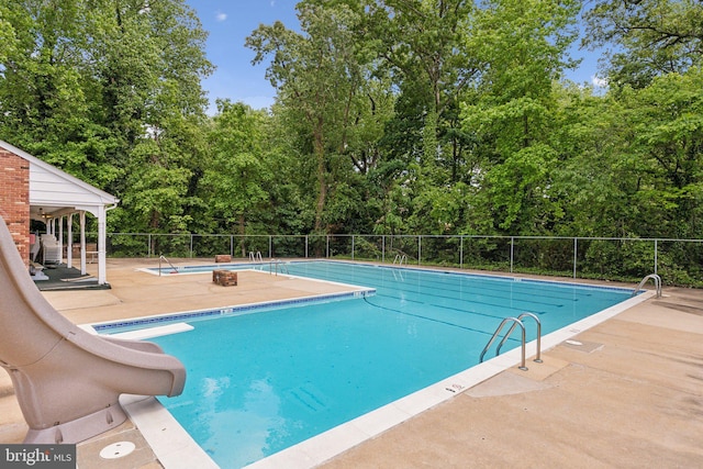1406 Catlyn Pl, Annapolis, MD 21401 - community pool featuring a water slide, view of scattered trees, and a patio
