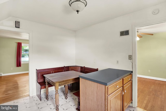 dining space with light wood-style floors, baseboards, ceiling fan, and visible vents