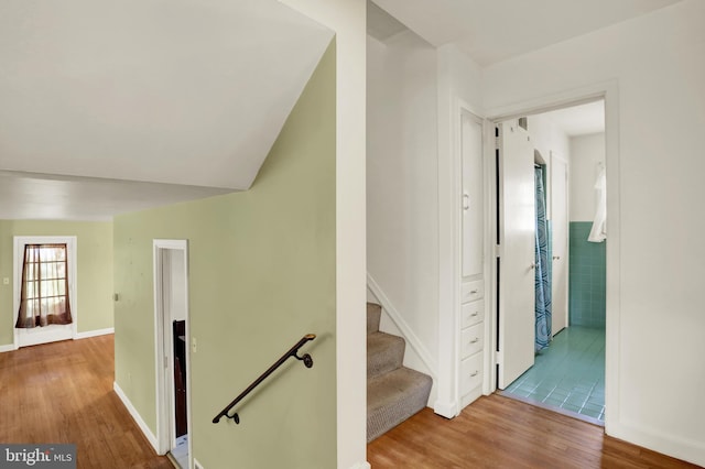 hall with baseboards and wood finished floors