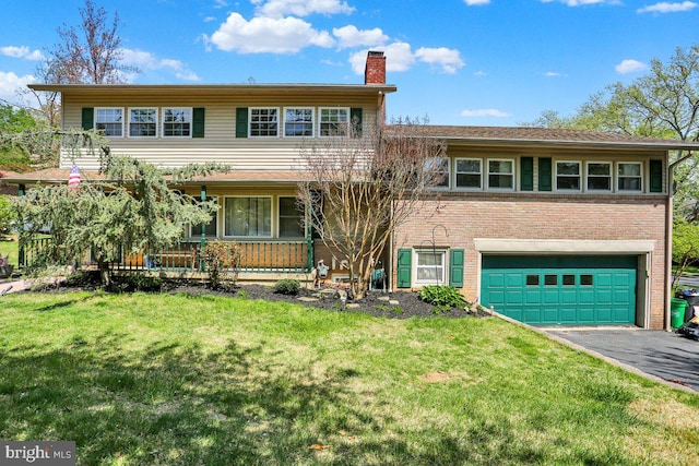 view of front facade featuring an attached garage, driveway, a chimney, and a front yard