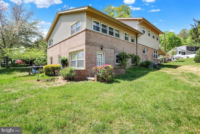 view of side of home featuring a yard and brick siding