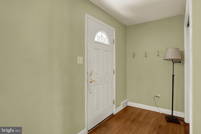 entryway with baseboards, hardwood / wood-style flooring, and visible vents