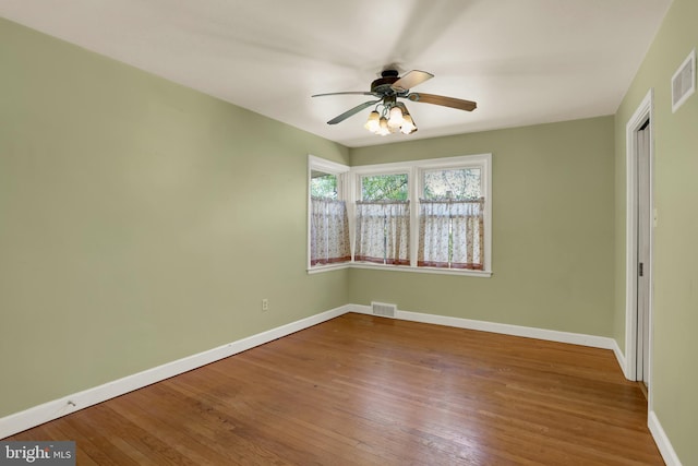 unfurnished bedroom with baseboards, a closet, hardwood / wood-style flooring, and visible vents