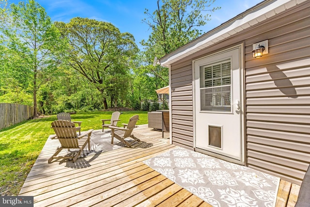 deck featuring fence and a yard