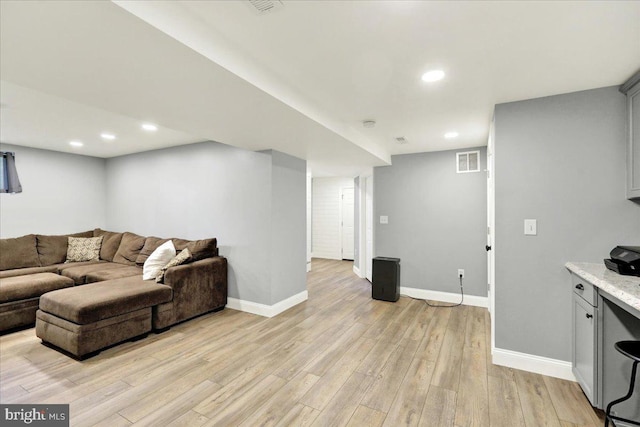 living room with recessed lighting, baseboards, light wood finished floors, and visible vents