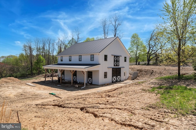 back of house featuring metal roof