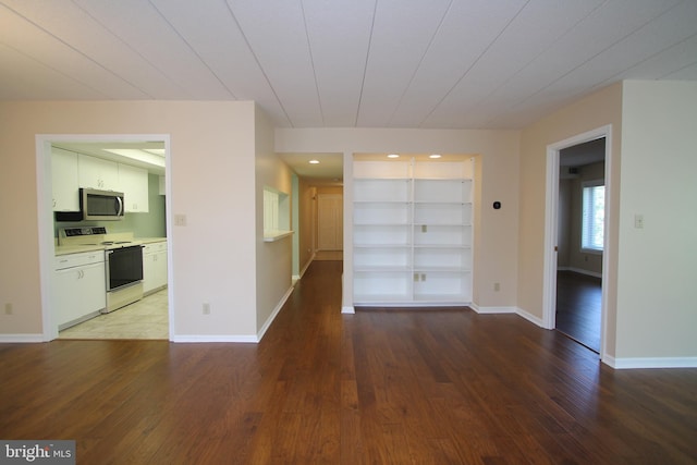 interior space featuring baseboards, built in features, and hardwood / wood-style floors