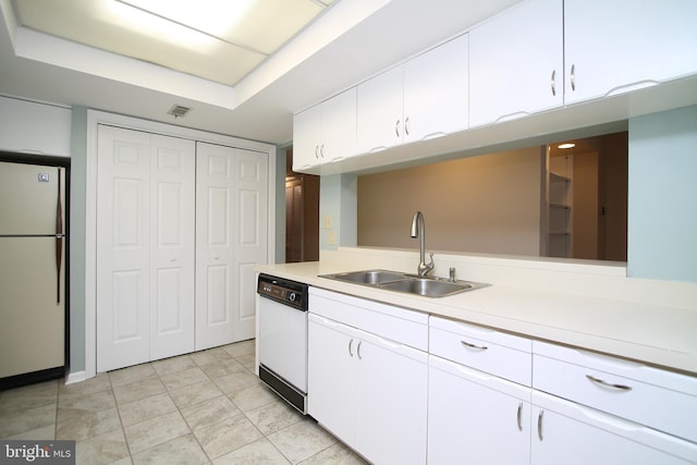 kitchen with visible vents, a sink, light countertops, white appliances, and white cabinetry