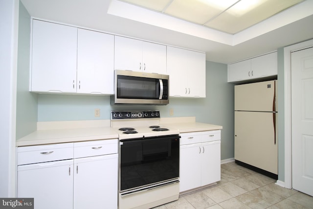 kitchen with freestanding refrigerator, light countertops, stainless steel microwave, and electric stove