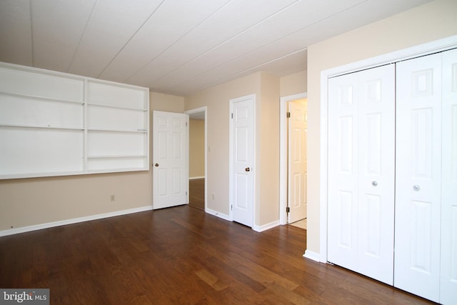 unfurnished bedroom with baseboards, a closet, and dark wood-style flooring