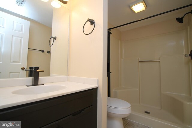 bathroom featuring visible vents, a shower, toilet, and vanity