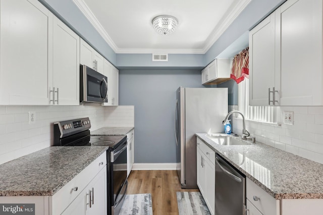 4927 Oxford Ct, Bensalem, PA 19020 - kitchen with visible vents, crown molding, tasteful backsplash, a sink, and stainless steel appliances