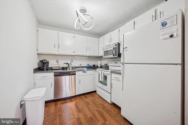 kitchen featuring dark countertops, a textured ceiling, white cabinetry, and stainless steel appliances