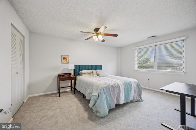 carpeted bedroom featuring baseboards, ceiling fan, a textured ceiling, and visible vents