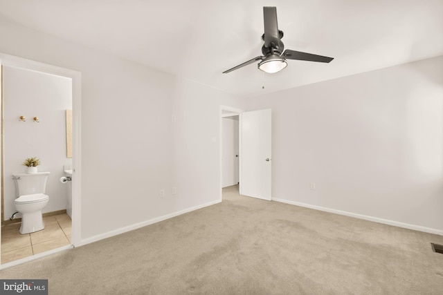 unfurnished bedroom with baseboards, ceiling fan, carpet flooring, and ensuite bath