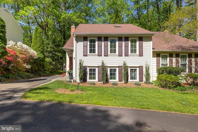 split level home with a chimney and a front yard