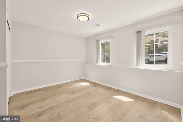 unfurnished room featuring baseboards and wood finished floors