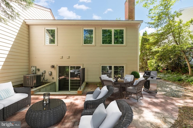 rear view of house with a patio, central AC, outdoor lounge area, and a chimney