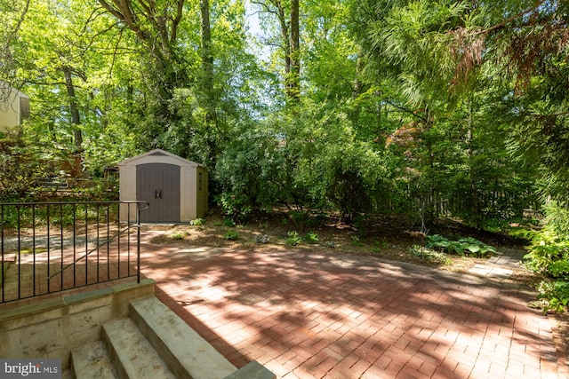 deck with a patio, an outbuilding, and a shed