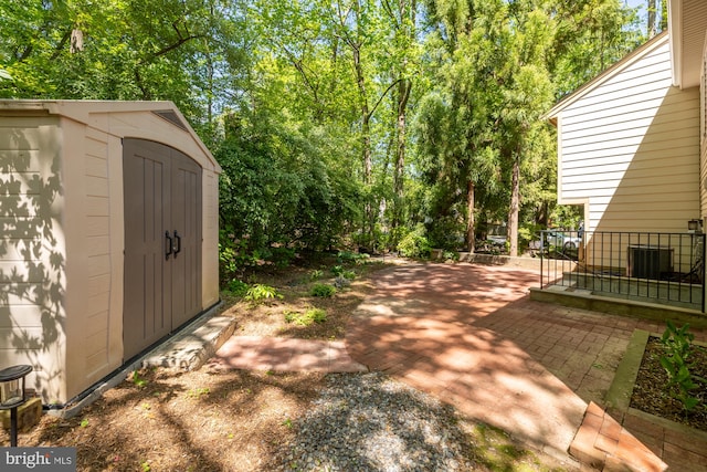 view of patio with an outdoor structure, a shed, and central air condition unit