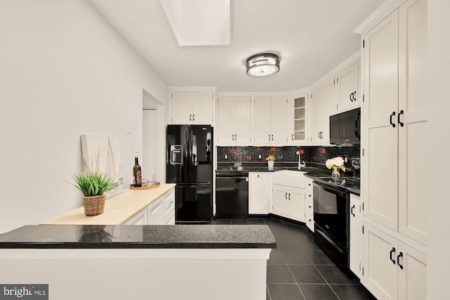 kitchen featuring dark tile patterned floors, dark countertops, tasteful backsplash, black appliances, and white cabinetry