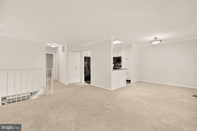 unfurnished living room with baseboards, ornamental molding, visible vents, and light colored carpet