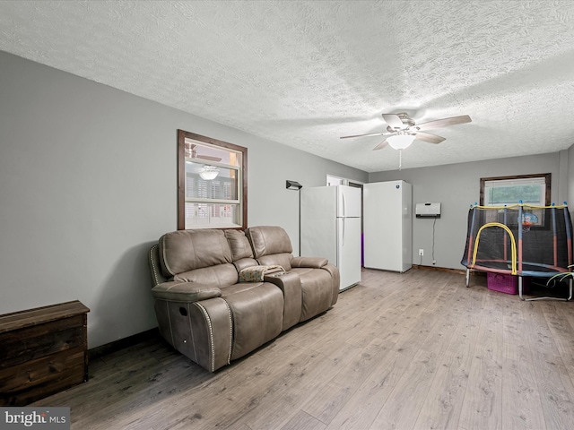 125 Ender Dr, Moorefield, WV 26836 - living room with a textured ceiling, light wood-style flooring, a ceiling fan, and baseboards