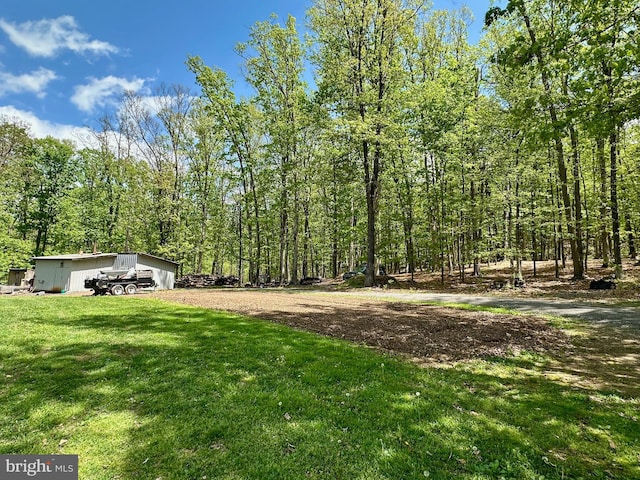 view of yard with a wooded view and an outdoor structure
