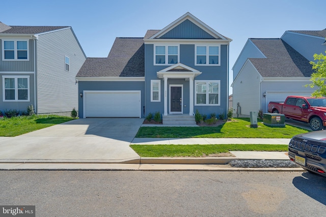 view of front of home featuring an attached garage, driveway, and a front yard