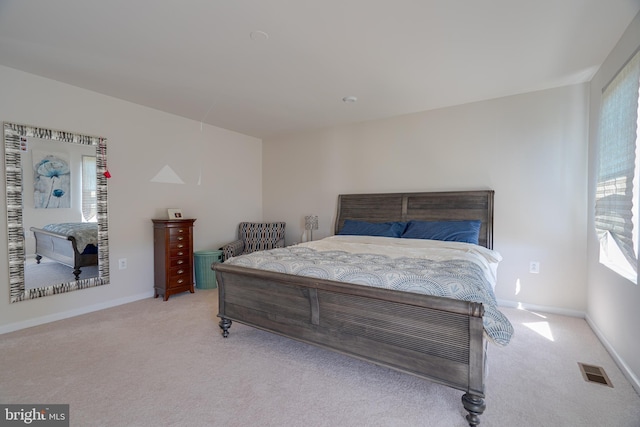 bedroom featuring baseboards, visible vents, and light carpet