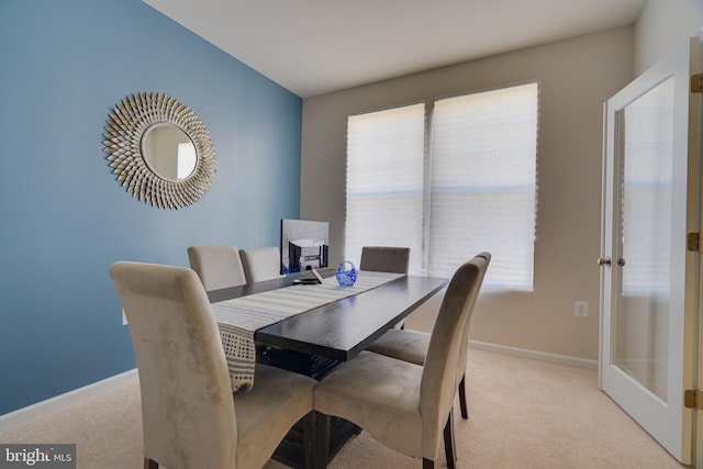 dining area with baseboards, light carpet, and french doors