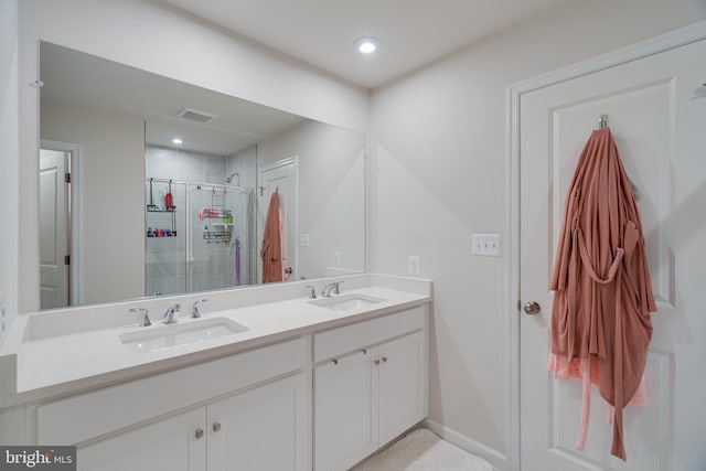 full bathroom featuring visible vents, a sink, double vanity, and a shower stall